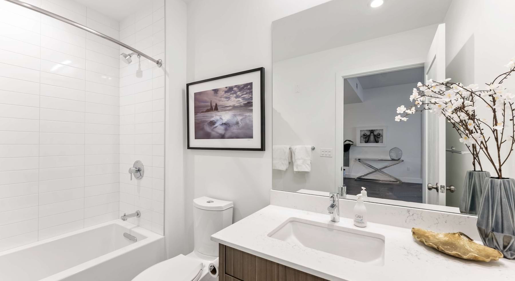 a spacious bathroom with a large mirror and ample light