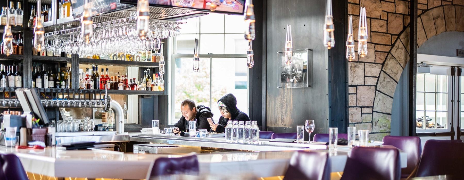 a couple of people sitting at a bar