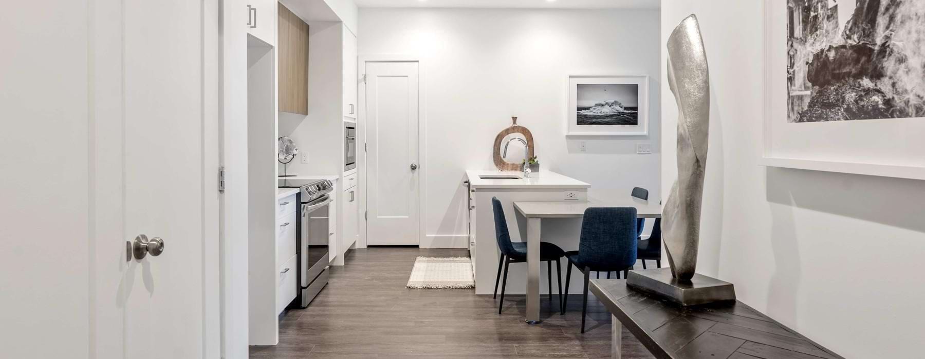kitchen area that connects to the hall and on wood-style flooring